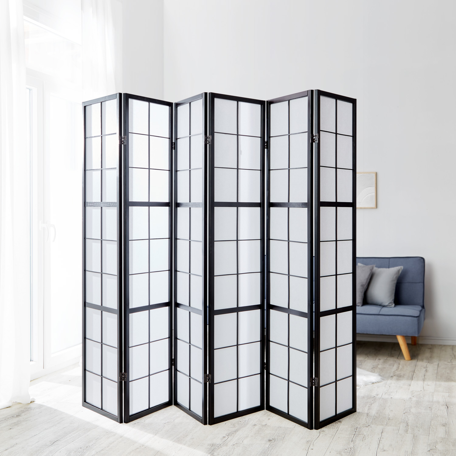 Paravent in Schwarz mit 6 beweglichen Elementen und Shoji-Design. Der Artikel ist freigestellt auf weißem Hintergrund abgebildet. Sichtbare Details sind mehrere gelenkig verbundene Paneele, ein regelmäßiges Holzraster und helle Paneelflächen.