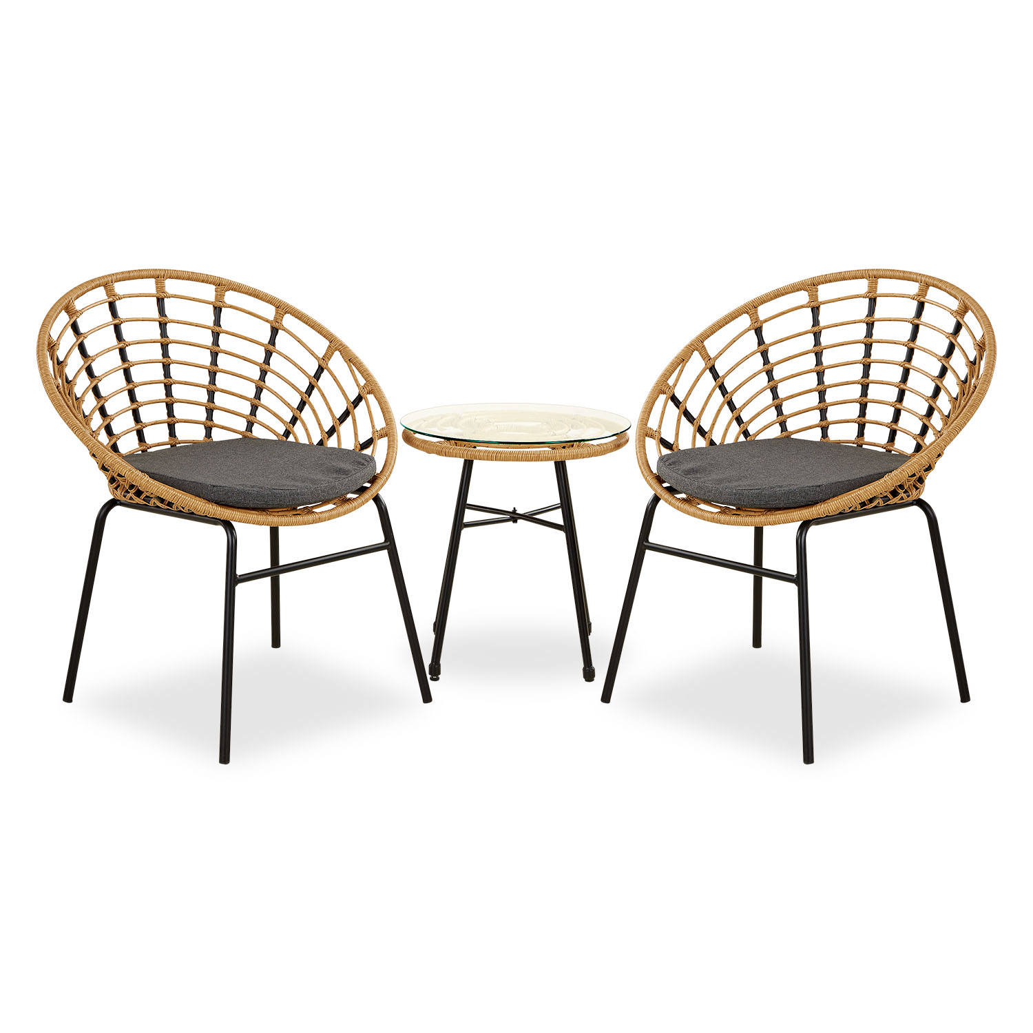 Gartenmöbel-Set mit Tisch und zwei Stühlen in Naturholzfarbe mit runder Tischform. Zwei naturfarbene geflochtene Sessel mit dunklen Sitzkissen stehen neben einem kleinen runden Tisch vor einer hellen Wand. Ein Getränk auf dem Tisch, eine Grünpflanze und e