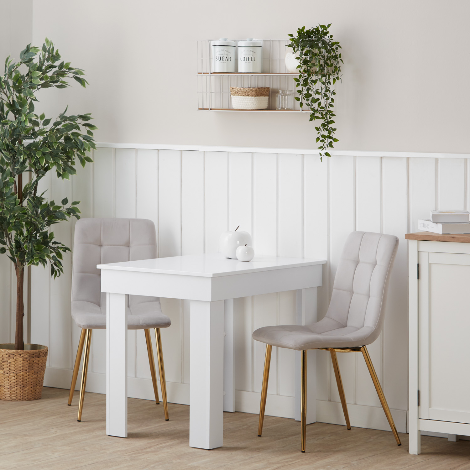 Essgruppe in Weiß und Creme mit Holzelementen und Samtbezug. Der Freisteller zeigt den Esstisch und 2 gepolsterte Stühle als separate Möbel auf weißem Hintergrund. Die gesteppten Rückenlehnen und die schlanken Stuhlbeine sind sichtbar.