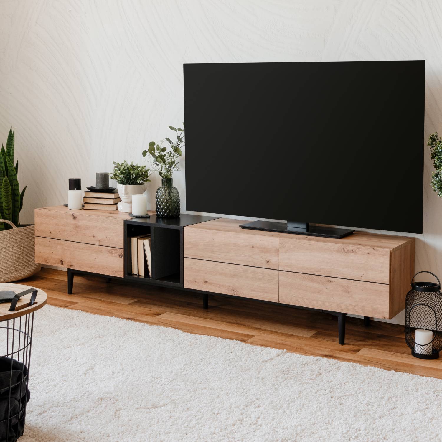 TV-Lowboard in Schwarz und Naturholzfarbe mit Holzelementen. Der Artikel ist freigestellt auf weißem Hintergrund abgebildet. Sichtbare Details sind Schubladenfronten, offene Ablagen, ein schwarzes Metallgestell und eine sichtbare Holzmaserung.