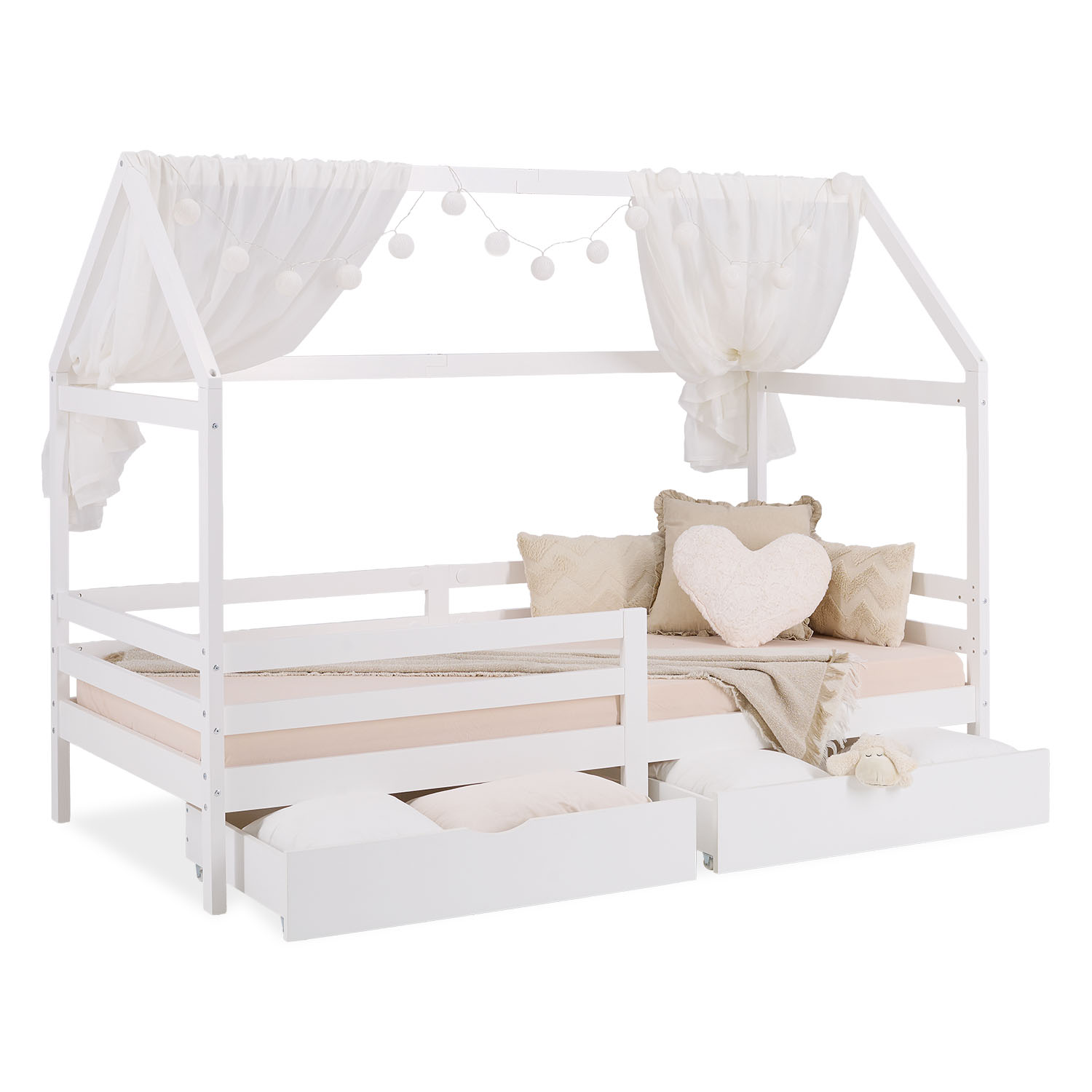 Kinderbett mit hausförmigem Rahmen in Weiß mit Holzelementen, Lattenrost, Stauraum und seitlichen Schutzgittern. In der eingerichteten Szene sind Bilderrahmen, ein heller Teppich und ein heller Boden zu sehen.