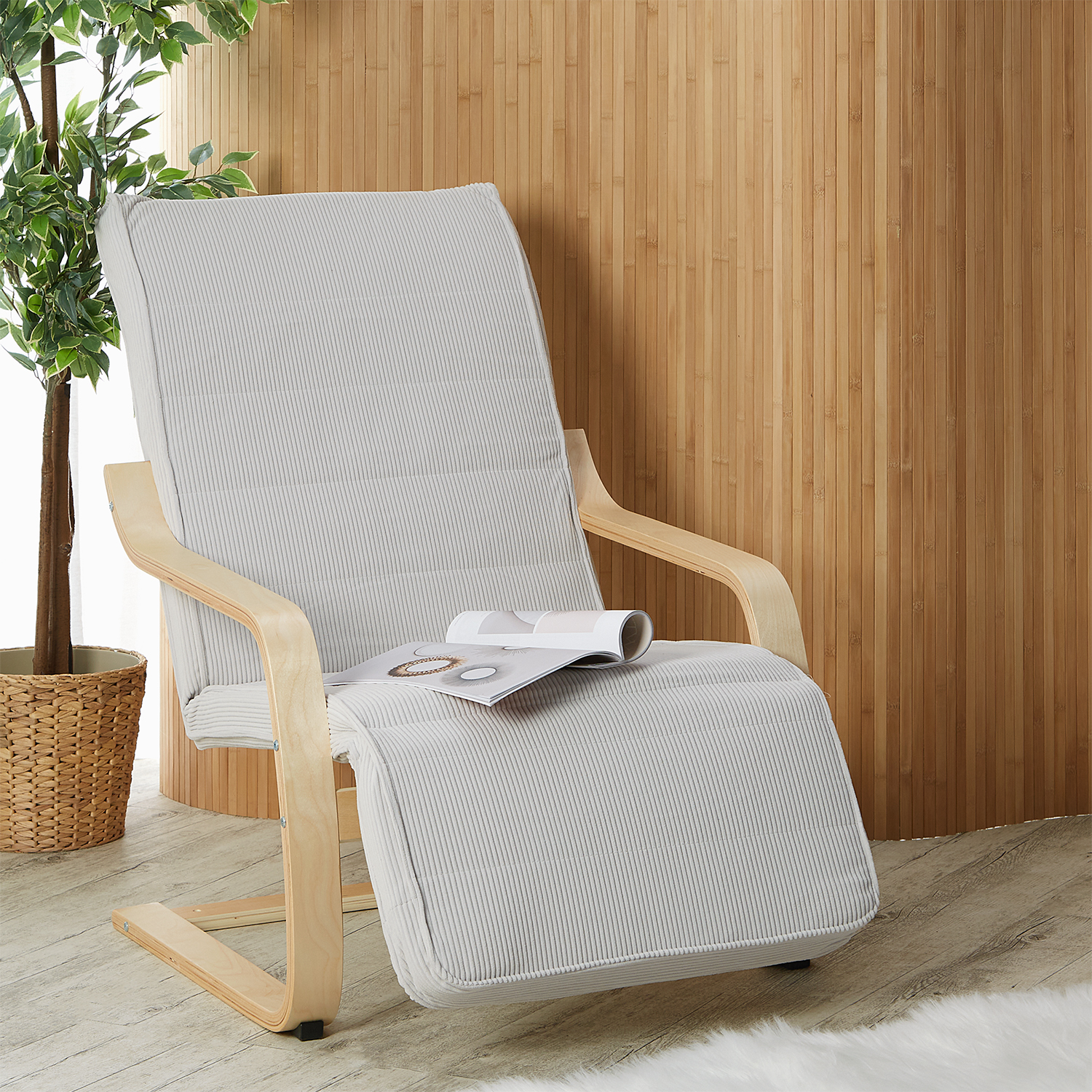 Relaxsessel in Grau und Naturholzfarbe mit Holzelementen und Cordbezug. Der gepolsterte Sessel mit gebogenen Holzarmlehnen und ausgezogenem gepolstertem Fußbereich ist einzeln vor weißem Hintergrund abgebildet. Kopfpolster, waagerechte Ziernähte und das g