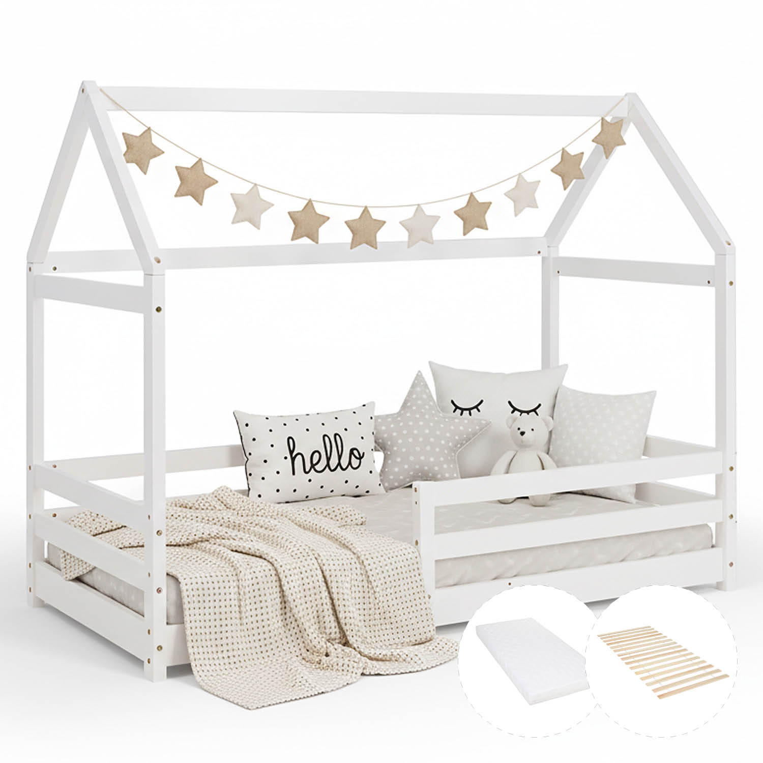 Hausbett mit Lattenrost, Matratze und seitlichen Schutzgittern. Das weiße Hausbett ist mit Matratze, Decke und Kissen vor weißem Hintergrund abgebildet. Eine Sternengirlande hängt am offenen Dachrahmen; die seitlichen Schutzleisten sind sichtbar.