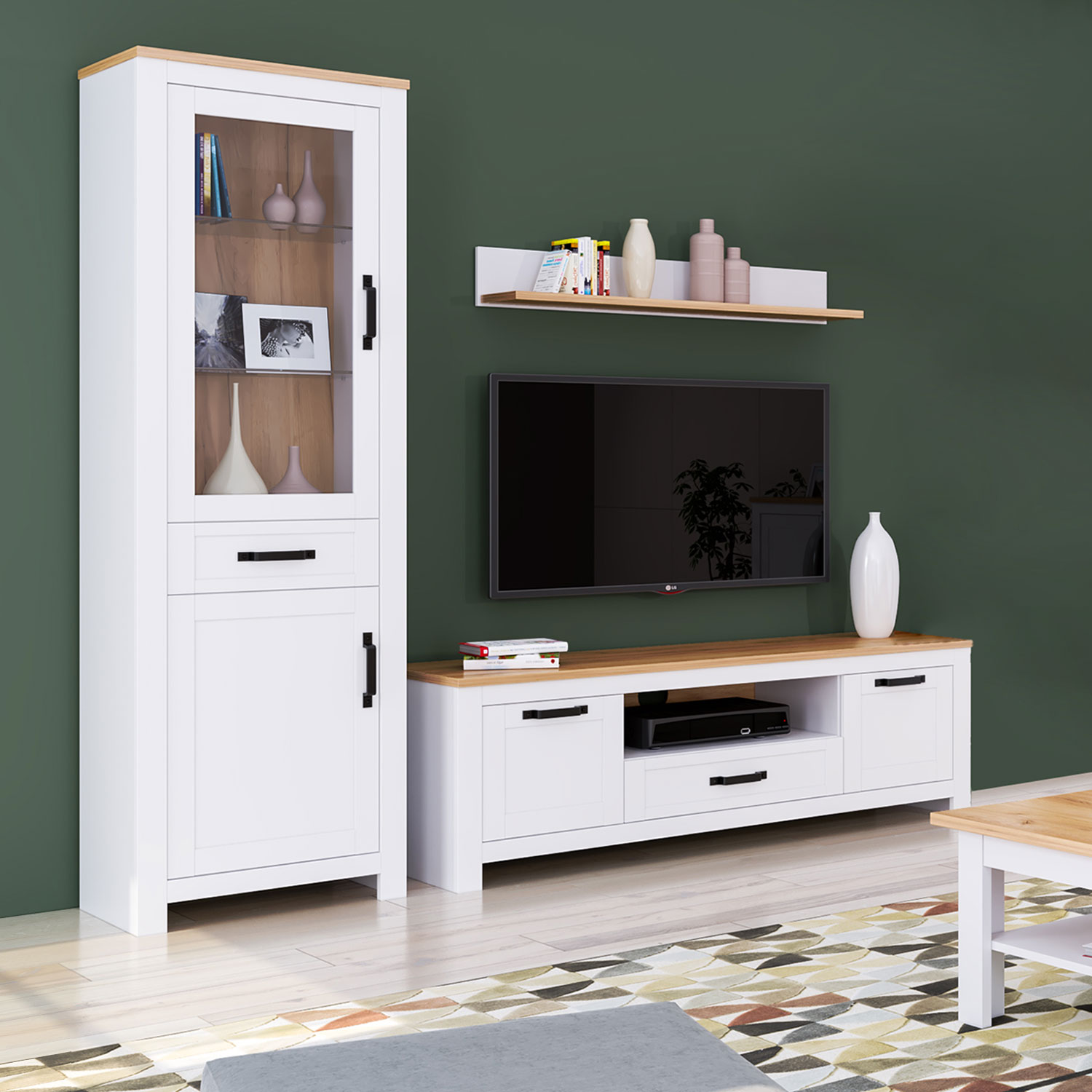 Vitrine in Weiß mit Oberflächen in Eichenoptik, Schubladenstauraum und Gestaltung im Landhausstil. Der Artikel ist freigestellt auf weißem Hintergrund abgebildet. Sichtbare Details sind geschlossene Schranktüren, offene Ablagen, waagerechte Griffe und ein