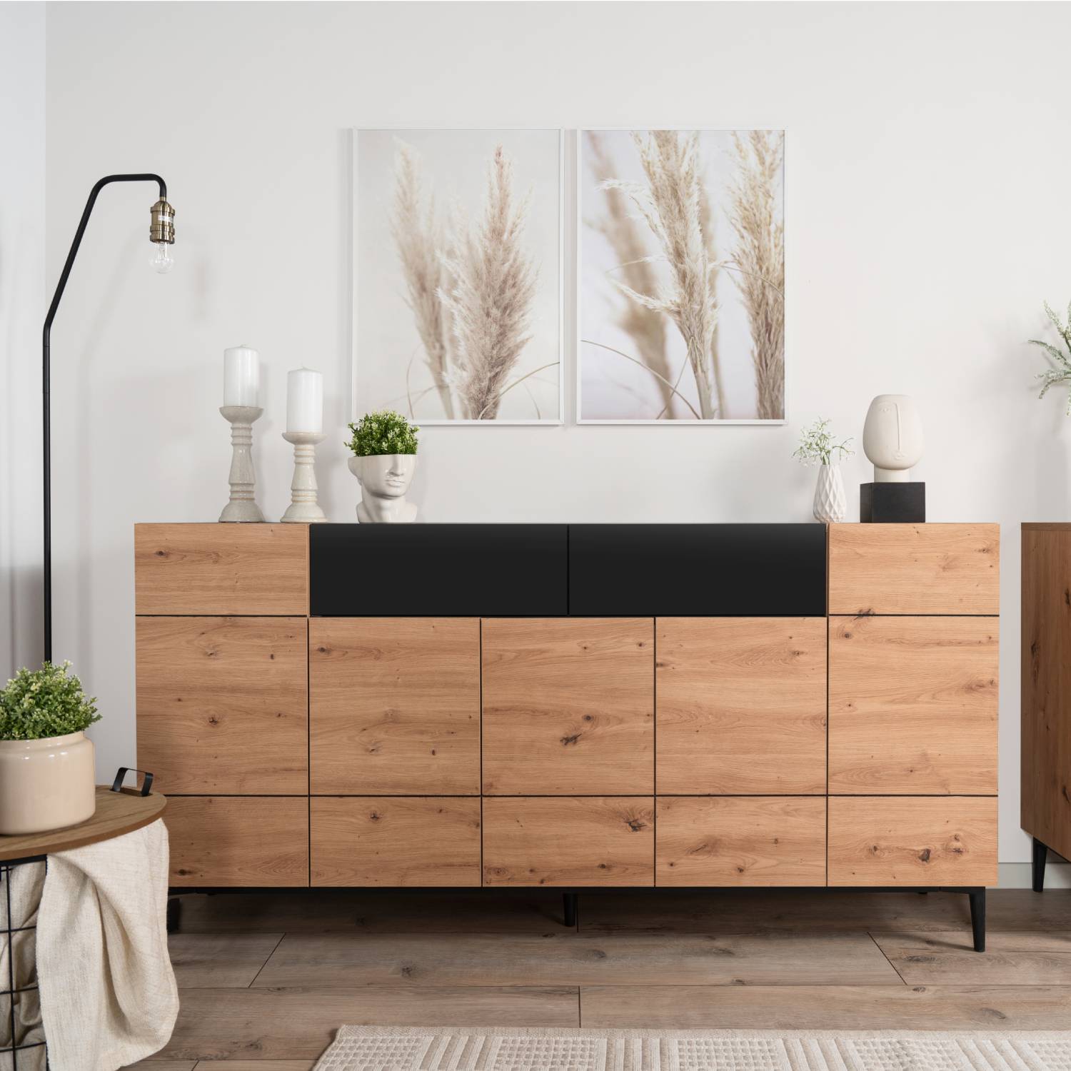 Kommode und Sideboard in Schwarz und Naturholzfarbe mit Oberflächen in Eichenoptik. Der Artikel ist freigestellt auf weißem Hintergrund abgebildet. Sichtbare Details sind geschlossene Schranktüren, ein schwarzes Metallgestell und eine sichtbare Holzmaseru