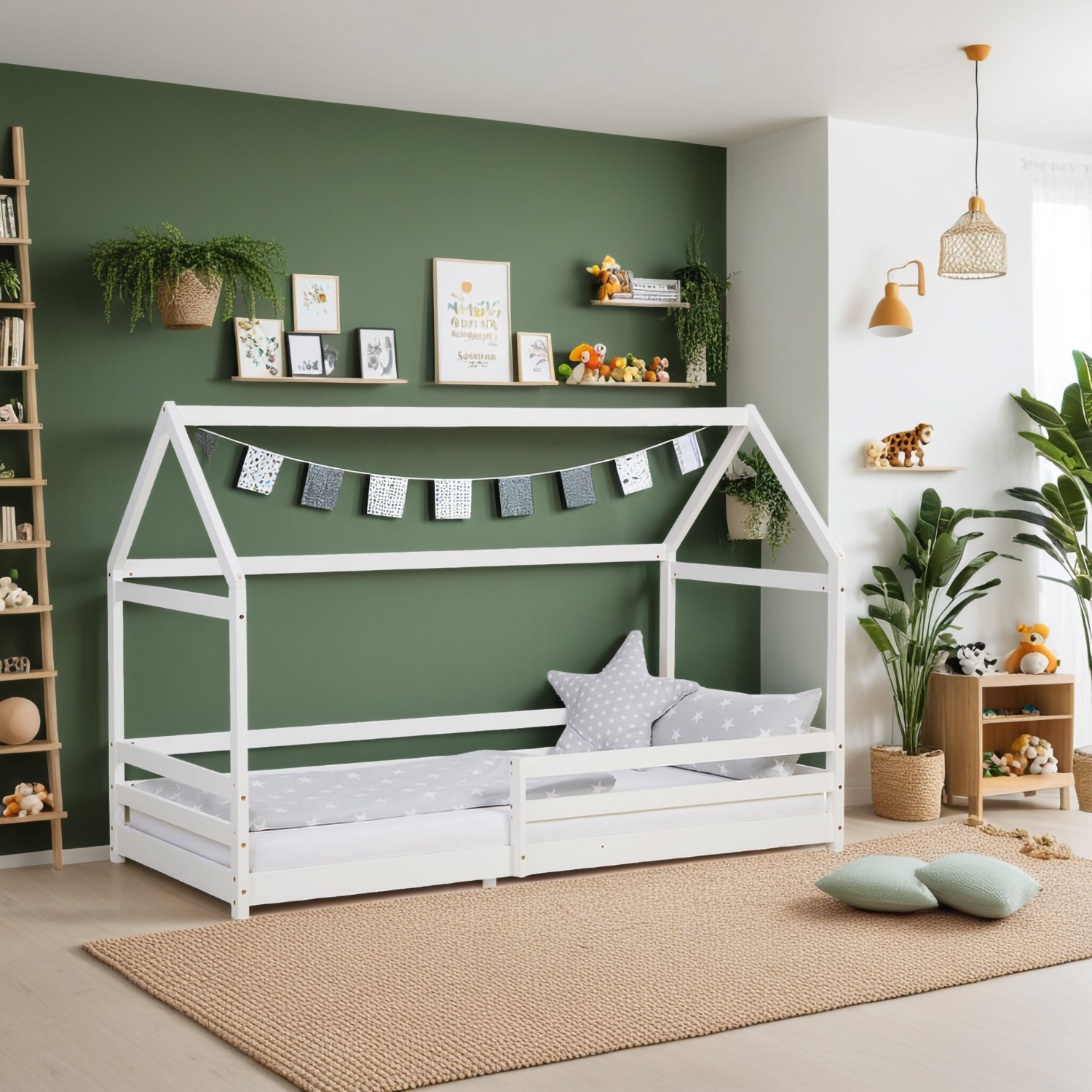 Kinderbett mit hausförmigem Rahmen mit Lattenrost und seitlichen Schutzgittern. Das Bettgestell ist mit Matratze, Bettwäsche und Kissen vor weißem Hintergrund abgebildet. Rahmen und Liegefläche sind in der schrägen Produktansicht sichtbar.