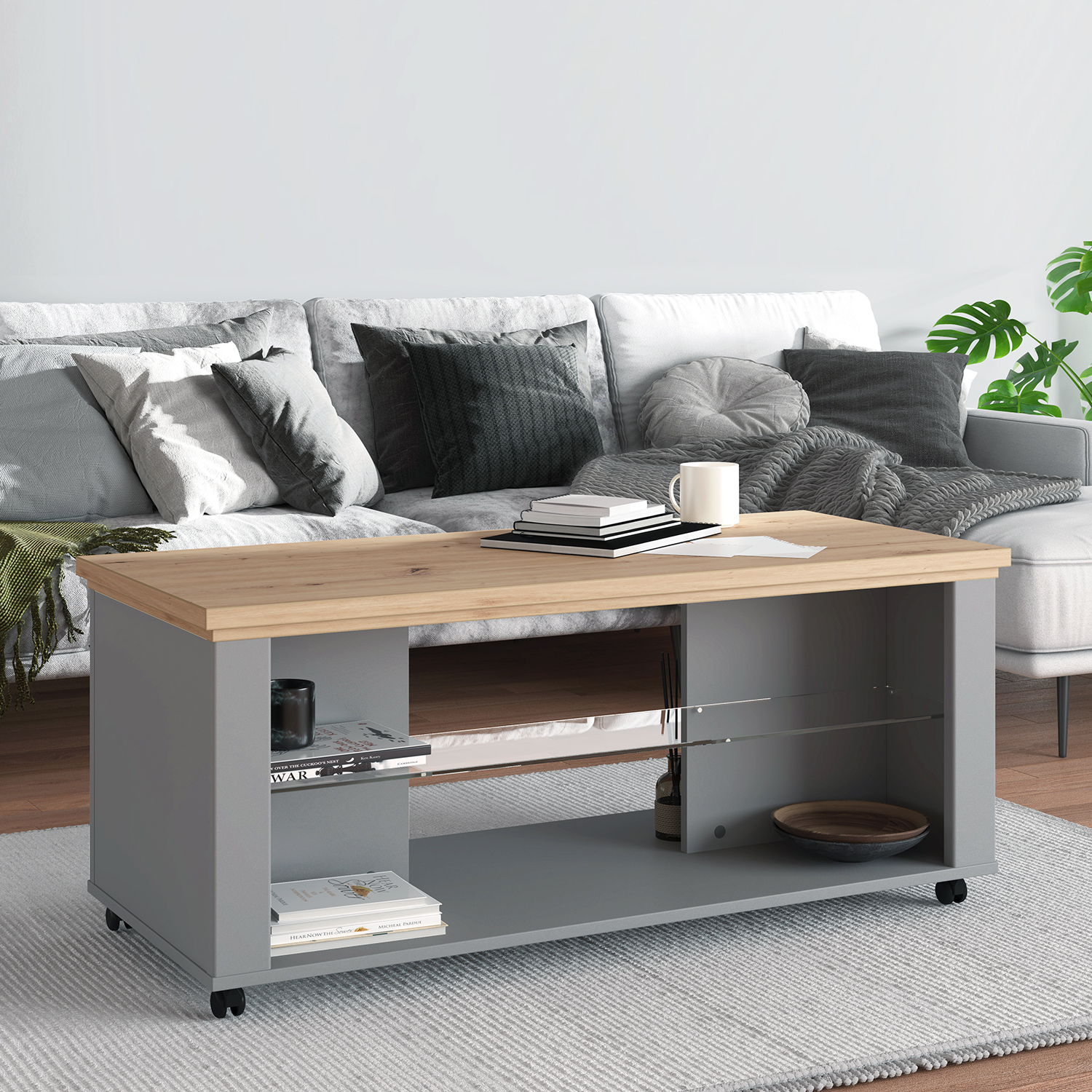 Couchtisch in Grau und Naturholzfarbe mit Holzelementen, Rollen und Stauraum. Der Artikel ist freigestellt auf weißem Hintergrund abgebildet. Sichtbare Details sind eine rechteckige Tischplatte, eine naturfarbene obere Holzplatte und offene Ablagen.