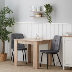 Essgruppe in Grau und Naturholzfarbe mit Holzelementen und Samtbezug. Der Freisteller zeigt den Esstisch und 2 gepolsterte Stühle als separate Möbel auf weißem Hintergrund. Die gesteppten Rückenlehnen und die schlanken Stuhlbeine sind sichtbar.